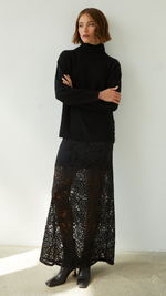 black turtleneck sweater paired with a black lace maxi skirt