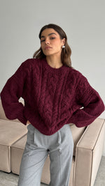 burgundy cable-knit sweater with a relaxed fit, styled with tailored light grey trousers