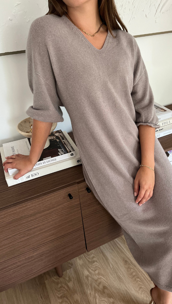 taupe knit midi dress with a V-neckline and three-quarter puff sleeves, accessorized with a gold necklace and bracelet